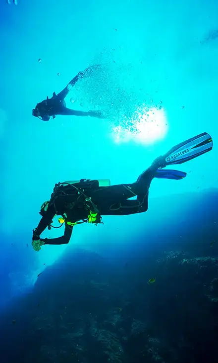 Man's head as he emerges to the sea surface after scuba diving in Tolo