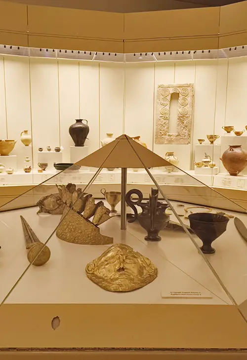 Glass display with gold mask, golden jewellery and a decorated sword in the Myceane archaeological museum